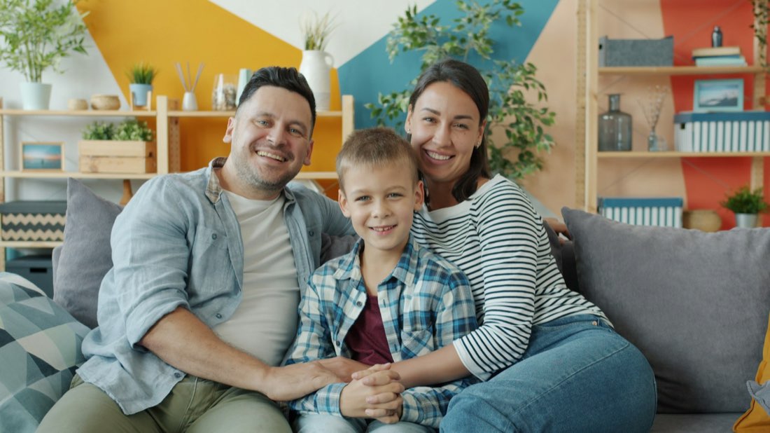 Uśmiechnięta rodzina na kanapie w domu